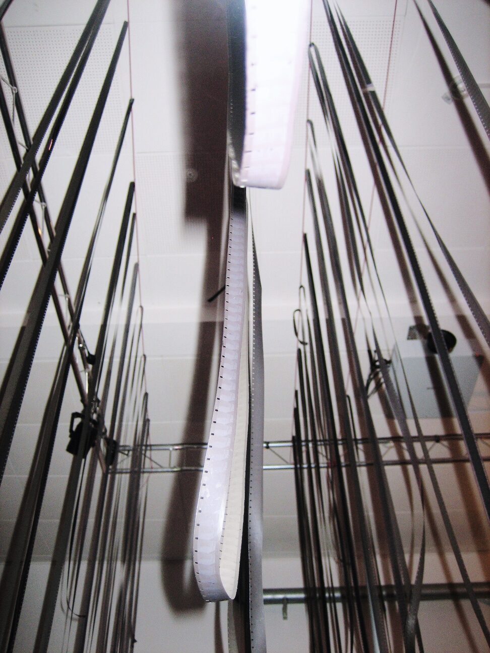Long strips of film hanging vertically to dry