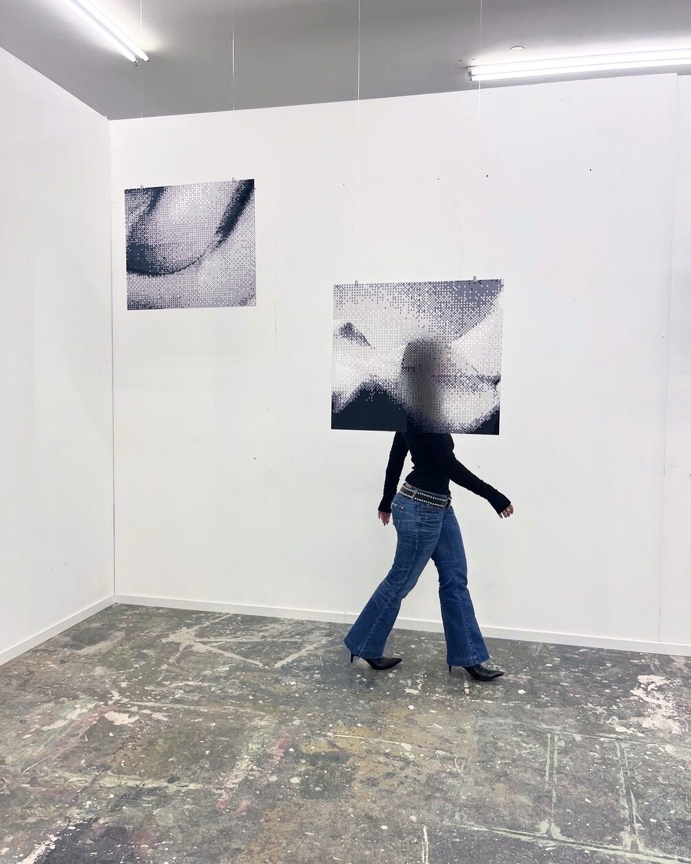 Visitor moving through the installation of transparent photographic prints