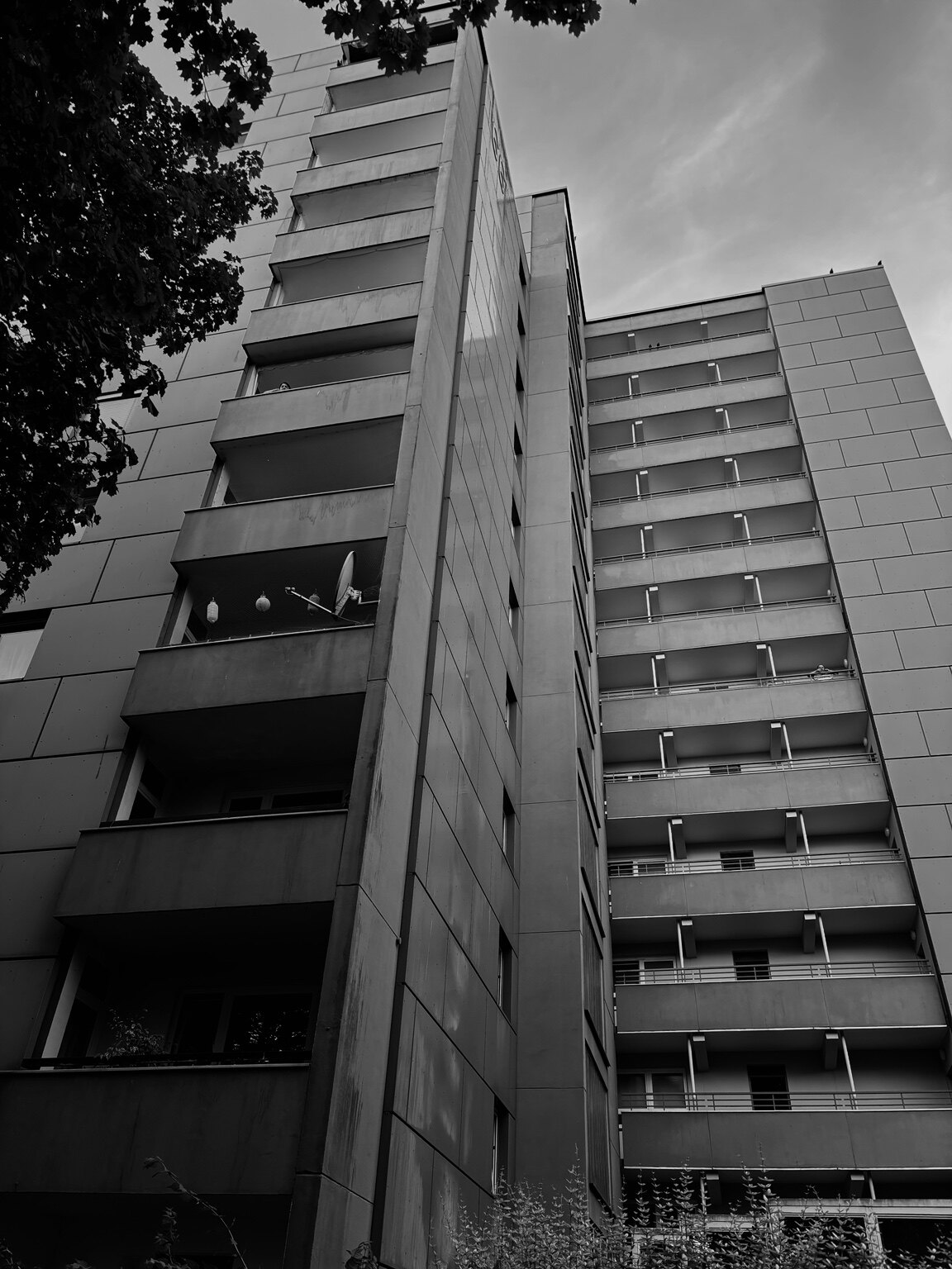 Black-and-white view looking up at a high-rise apartment building