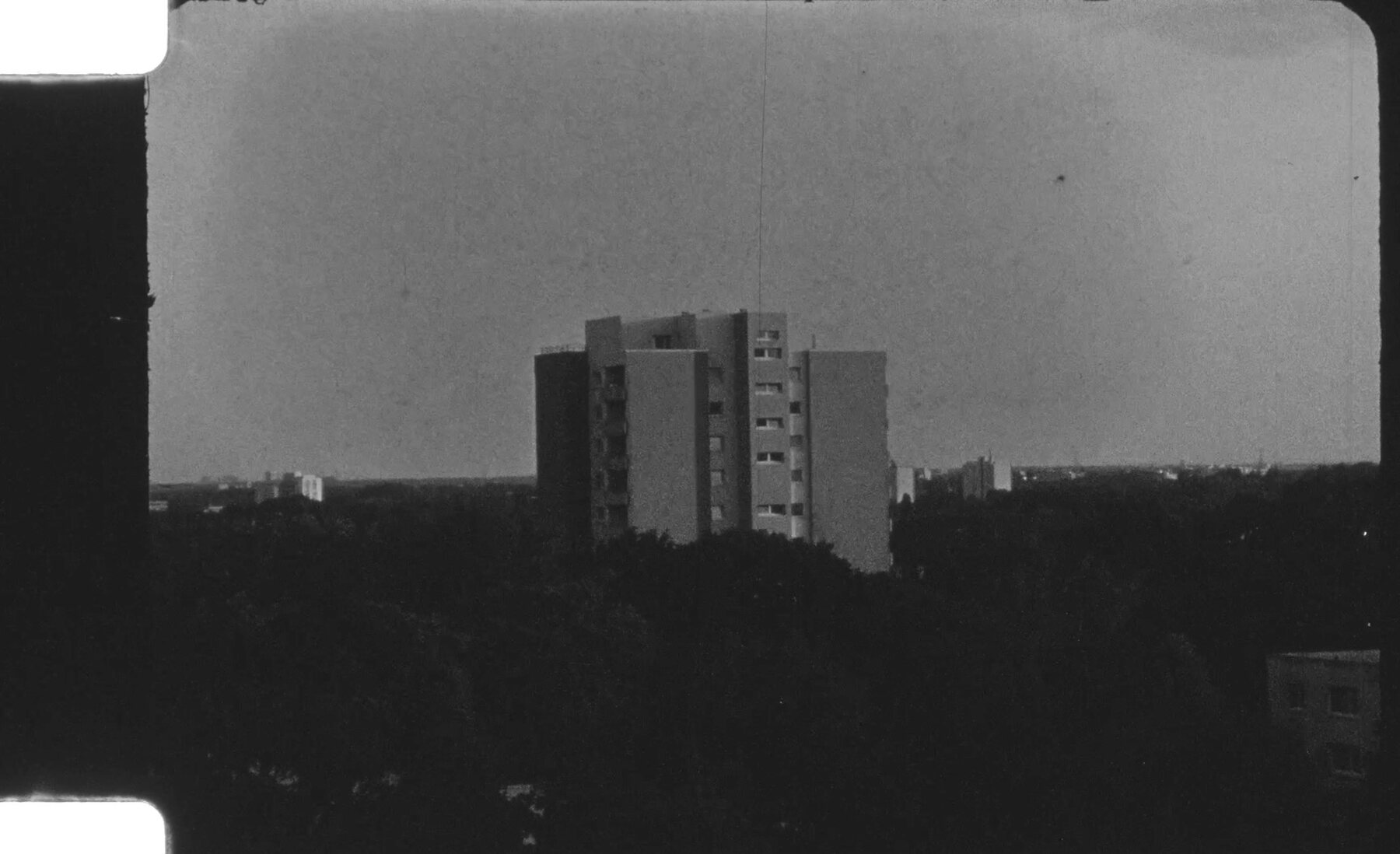 Distant high-rise building in a dark black-and-white landscape